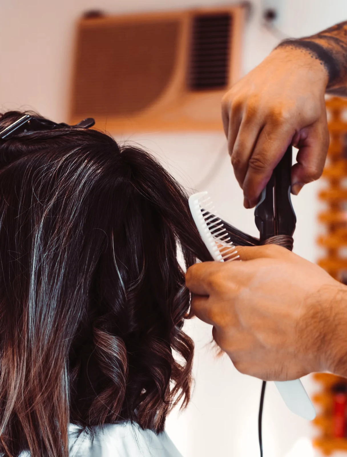 Estilista corta y peina el cabello largo de una clienta